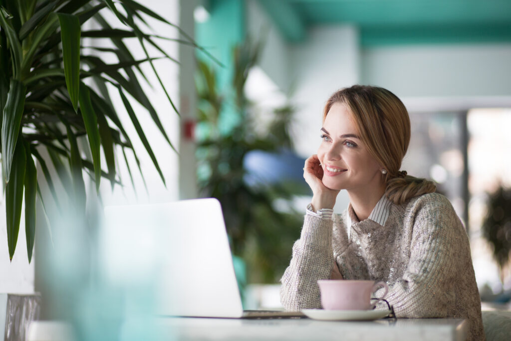 happy businesswoman dreaming in cozy cafe